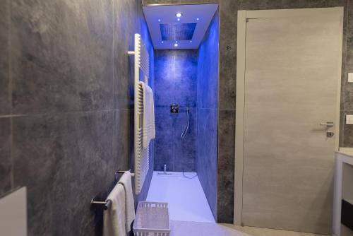 a bathroom with a toilet and a shower with blue lighting at Magic Luxury Apartments in Bardolino