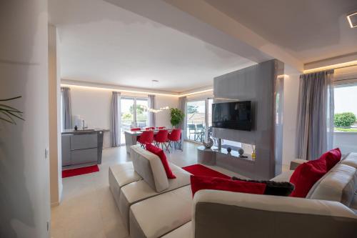 a living room with white furniture and red pillows at Magic Luxury Apartments in Bardolino