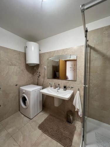 uma casa de banho com um lavatório e uma máquina de lavar roupa em Ana Exclusive Apartments em Jelsa