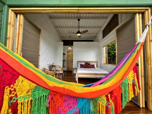 a colorful hammock in a room with a bed at Casa Galú - Capurganá in Capurganá