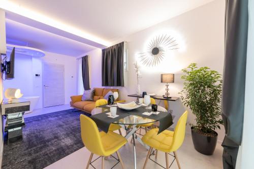 a living room with a table and yellow chairs at Magic Luxury Apartments in Bardolino