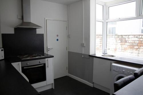 a kitchen with a stove and a sink and a window at Bursar Street 19 in Cleethorpes