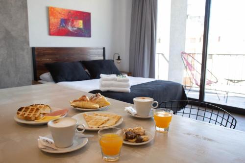 a table with breakfast foods on it with a bed at Days Inn Devoto in Buenos Aires