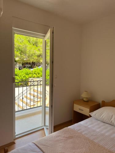 1 dormitorio con 1 cama y puerta a un balcón en Ana Exclusive Apartments, en Jelsa