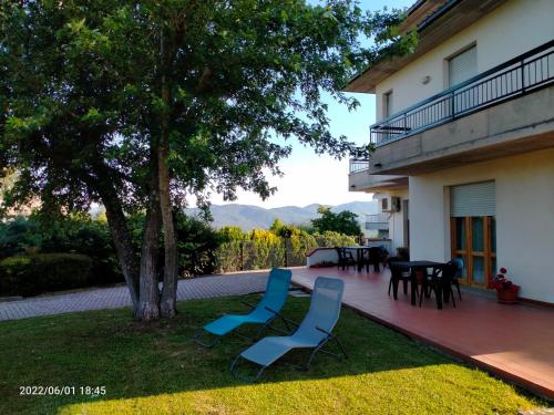une terrasse avec 2 chaises, une table et un arbre dans l'établissement Casa del Carmine, à Anghiari