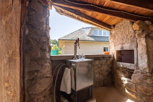 an outdoor kitchen with a stove and a stone wall at Casa Montellos in Betanzos