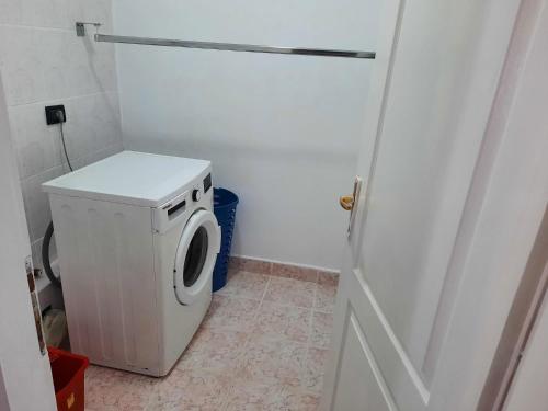 eine weiße Waschmaschine im Bad mit Tür in der Unterkunft Apartament deosebit in Reşiţa