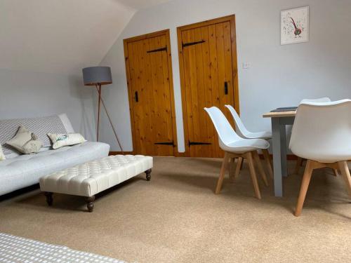 salon ze stołem, krzesłami i biurkiem w obiekcie The Stables, charming converted, 2 bedroom Cottage, Melrose w mieście Darnick
