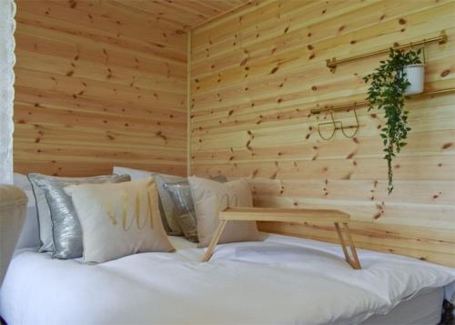 a bedroom with a white bed with a wooden wall at Fine Country Stays in Bubwith