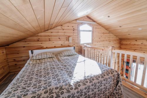 a bedroom with a bed in a wooden cabin at Tiittalan Kartano in Sulkava