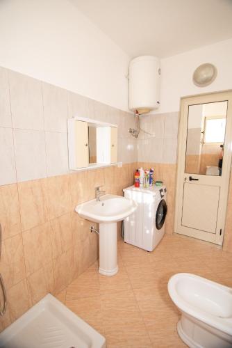 a bathroom with a sink and a washing machine at AMI apartament in Vlorë