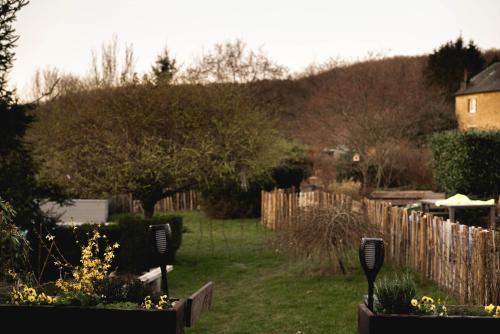 a backyard with a fence and a yard with flowers at Il était une fois in Herbeumont
