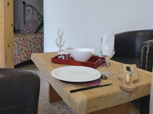 a wooden table with a plate and glasses on it at In casa in Casta