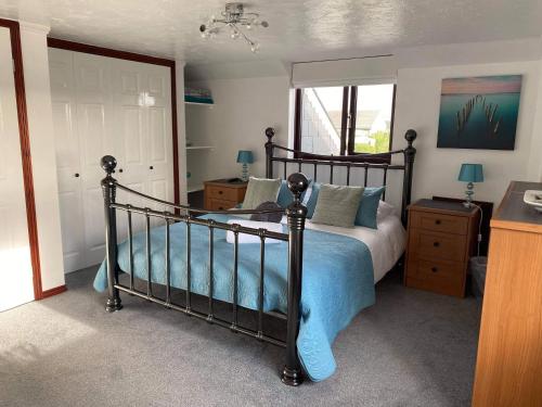 a bedroom with a bed with a blue comforter at Meadowview Cottage, St Ives View in Camborne