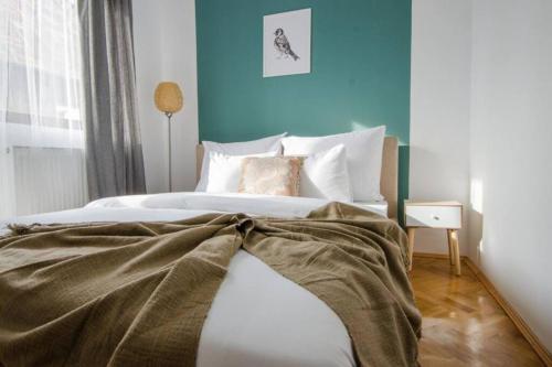 - une chambre dotée d'un lit avec un mur bleu dans l'établissement Stylized and modern apartment in Bucharest, à Bucarest