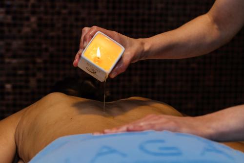 a person holding a candle over a man in a pool at Gran Hotel Nagari Boutique & Spa in Vigo