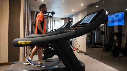 a man walking on a treadmill in a gym at Gran Hotel Nagari Boutique & Spa in Vigo