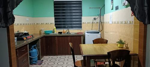 una pequeña cocina con mesa y fregadero en RUMAH INAP BANDAR PERDANA, en Sungai Petani