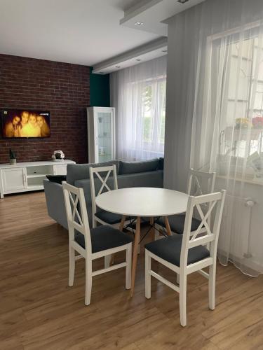 a living room with a white table and chairs at Apartament na Mazowieckiej in Kołobrzeg