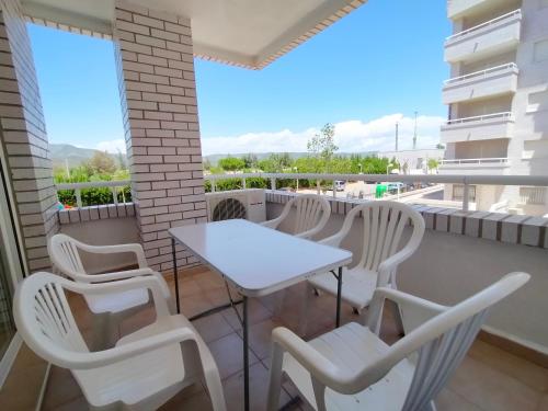 a balcony with white chairs and a white table at ACV - Marina Trebol III-2ª linea planta 1 norte-3h in Oropesa del Mar
