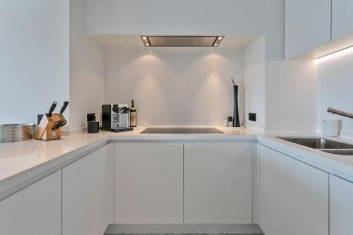 a white kitchen with white cabinets and a sink at Top location! Unique luxurious 3-bedroom apartment in Knokke - 't Zoute in Knokke-Heist