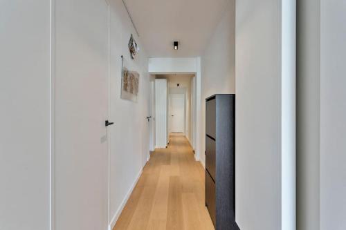 a hallway of a house with white walls and wooden floors at Top location! Unique luxurious 3-bedroom apartment in Knokke - 't Zoute in Knokke-Heist