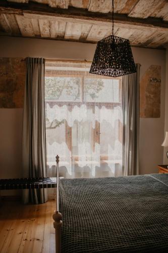 a bedroom with a bed and a large window at Zelta Apelsīna apartamenti in Kuldīga