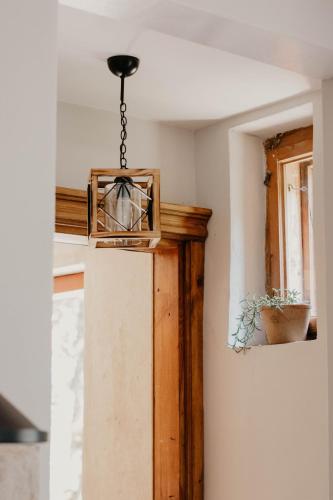 aendant light hanging from a ceiling in a room at Zelta Apelsīna apartamenti in Kuldīga