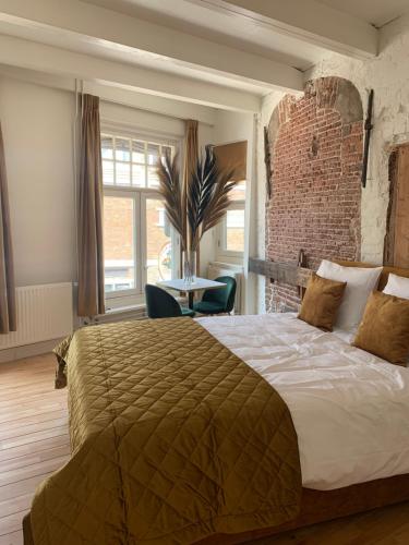 a bedroom with a large bed and a brick wall at Monroe’s stay in Deventer
