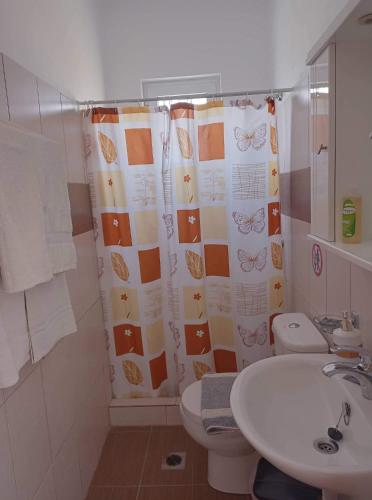 a bathroom with a sink and a toilet and a shower curtain at ZOGRAFOS 1 in Haraki