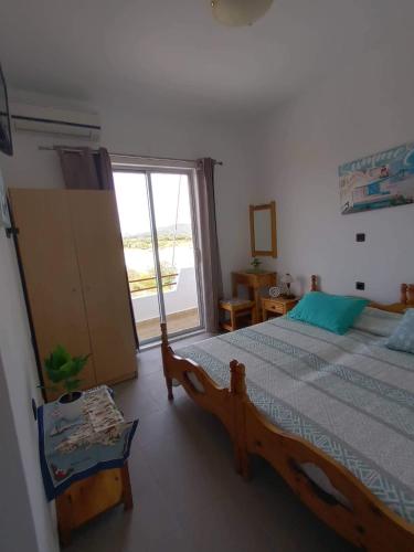 a bedroom with a bed and a large window at ZOGRAFOS 1 in Haraki