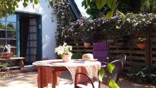 a table with a hat and chairs on a patio at Ferienhaus Prerow in Prerow