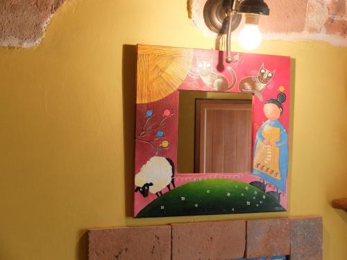ein Spiegel an der Wand mit einem Gemälde darauf in der Unterkunft case vacanza da Rosina e T in Santo Stefano di Sessanio