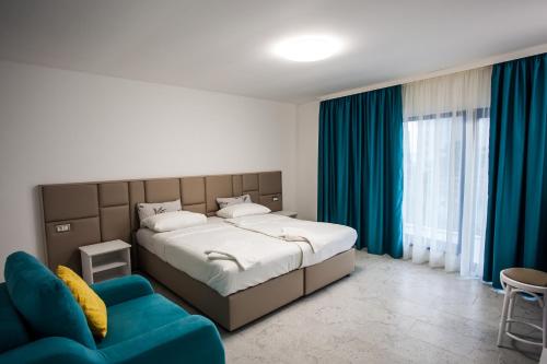 a bedroom with a large bed and a blue couch at Вила Чайка, Villa Chaika in Balchik