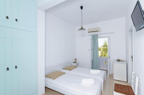 um quarto branco com uma cama e uma janela em Galini Studios em Maltezana