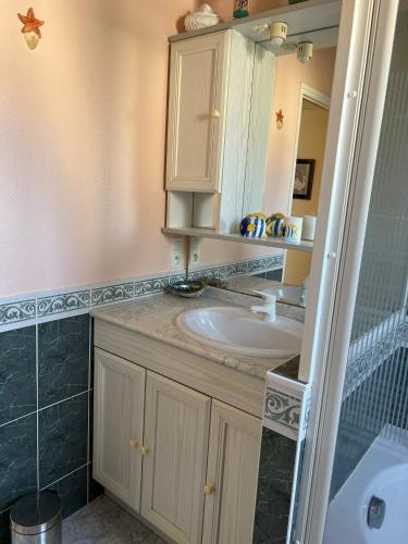 une salle de bain avec un lavabo et un miroir dans l'établissement Kêr Korrigan - Villa familiale, à Saint-Gildas-de-Rhuys