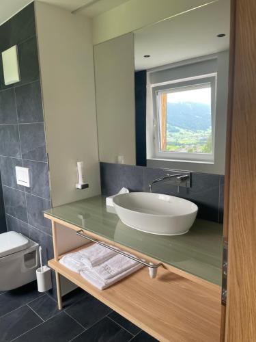 a bathroom with a sink and a mirror at Panoramahotel Sonnhalde in Schwarzenberg im Bregenzerwald