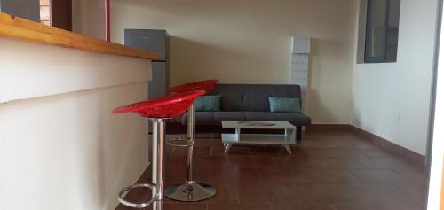a living room with a couch and two red stools at Le Rahma in Sada