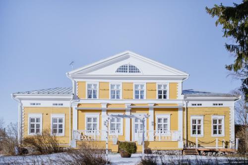 ein großes gelbes Haus mit weißem Dach in der Unterkunft Tiittalan Kartano in Sulkava