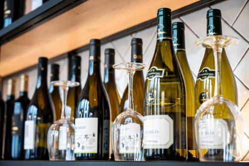 a row of wine bottles and glasses on a shelf at Staycity Aparthotels Paris La Defense in Courbevoie