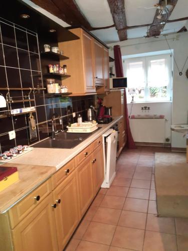 une cuisine avec des armoires en bois et un évier dans l'établissement La Maison des Tanneurs, à Ribeauvillé