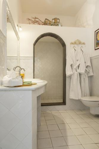 a white bathroom with a sink and a toilet at Hotel Lisca Bianca in Panarea