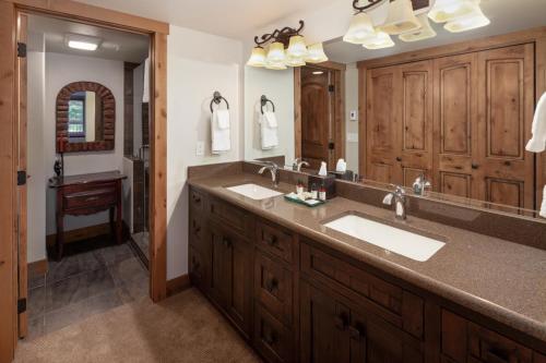 baño con 2 lavabos y espejo grande en Lodge at Whitefish Lake en Whitefish