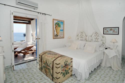- une chambre blanche avec un lit et un balcon dans l'établissement Hotel Lisca Bianca, à Panarea