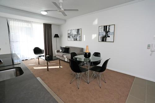 a living room with a table and chairs and a couch at Q Resorts Paddington in Townsville