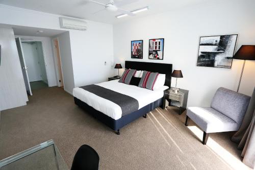 a bedroom with a bed and a chair in it at Q Resorts Paddington in Townsville