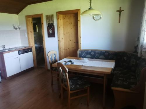 a dining room with a table and a cross on the wall at Biobauernhof und Ferienhaus Riederbauer in Rettenschöss