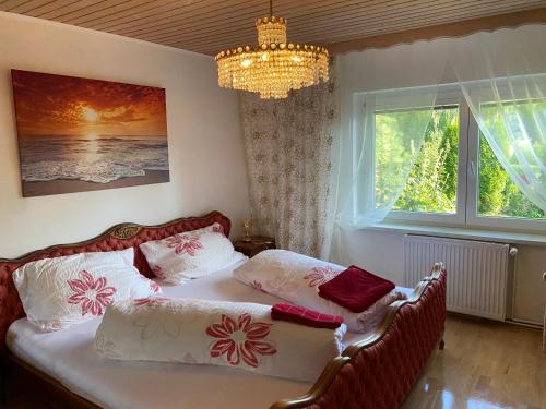Schlafzimmer mit einem Bett und einem Kronleuchter in der Unterkunft Pension Hadanig in Techelsberg am Worthersee