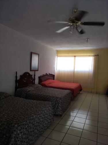 a bedroom with two beds and a ceiling fan at HOTEL PREMIER RIOVERDE in Río Verde