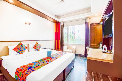 um quarto de hotel com uma cama e uma televisão em FabHotel Marble Arch em Nova Deli